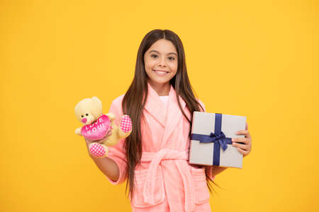 happy teen girl in home terry bathrobe with toy and present box, discountの写真素材