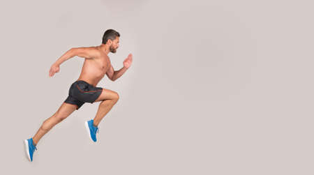 sportsman man runner run to success or jump high on grey background, copy space, sport