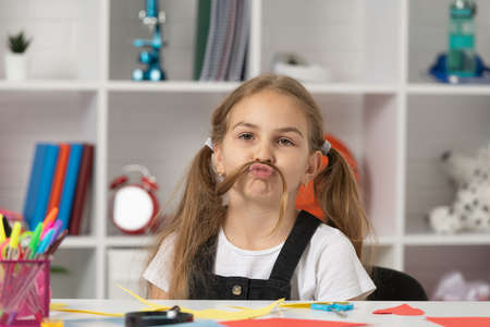 cute kid having fun with long hair pony tail at school lesson in classroom wear uniform, have funの写真素材