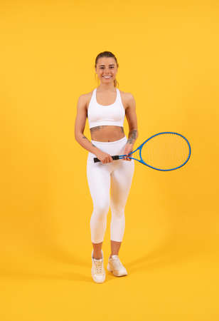 summer activity. cheerful young girl in sportswear with racket. sportswoman. sexy woman with racket on yellow background. female tennis player. badminton game racquet. sport game and hobby.の写真素材