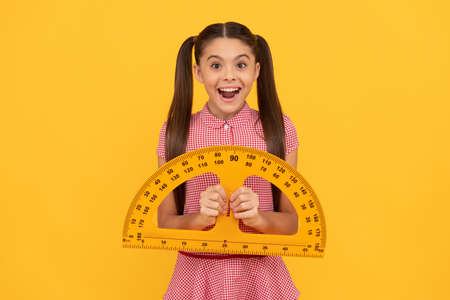 amazed teen girl hold protractor ruler. back to school. algebra and geometry.の写真素材