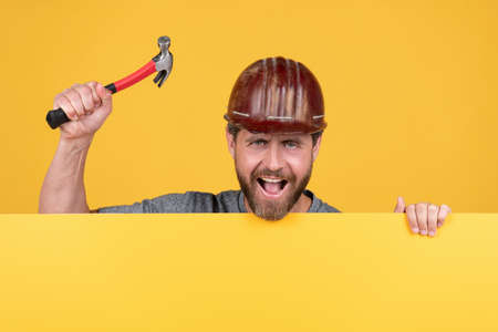 announcement. happy labour day. happy mature man in helmet with hammer.の写真素材