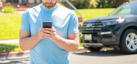 real estate agent at car for sale. realtor work online on smartphone. rent or buy new car.の写真素材