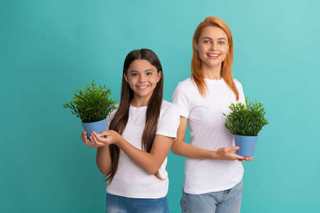 Fostering and adoption. Happy adopted child and mother hold houseplants. Foster family. Fosteringの写真素材