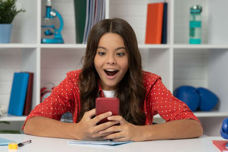 surprised child typing and texting. sms and instant messaging. modern communicationの写真素材
