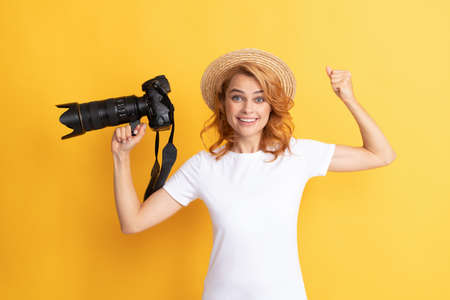 glad woman in straw hat photographing. girl hold photo camera.の写真素材
