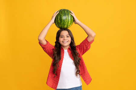 happy kid holding heavy fresh ripe water melon fruit in summer straw hat, dietの写真素材