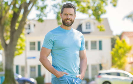 cheerful mature man standing outdoor at house, customer