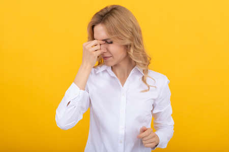 Tied woman broker suffer from fatigue and headache yellow background, stressの写真素材