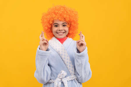 funny kid in curly clown wig. fancy child wear home bathrobe.の写真素材