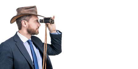 Professional man in cowboy hat look through binoculars isolated on white copy space, business visionの写真素材