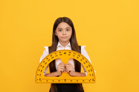 serious child in school uniform hold mathematics protractor for measuring, high schoolの写真素材