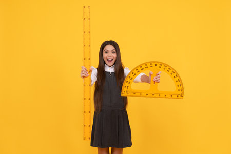 happy teen girl hold protractor ruler. back to school. algebra and geometry. kid study math.の写真素材