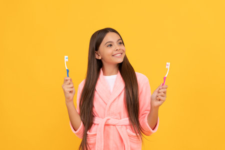 dreamy happy teen girl in home terry bathrobe hold toothbrush, healthの写真素材
