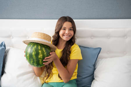 happy child hold fresh ripe water melon fruit in summer straw hat, foodの写真素材