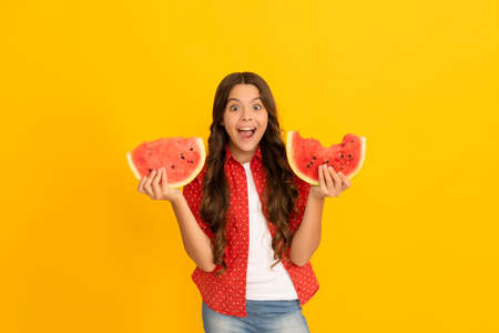 happy shocked child hold water melon slice. yummy juicy watermelon. kid with fruit.の写真素材