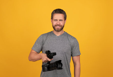 cheerful bearded man videographer making movie for vlog with camcorder, videoの写真素材