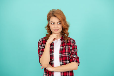 thinking redhead woman casual style. express positive emotions. lady with curly hair.の写真素材