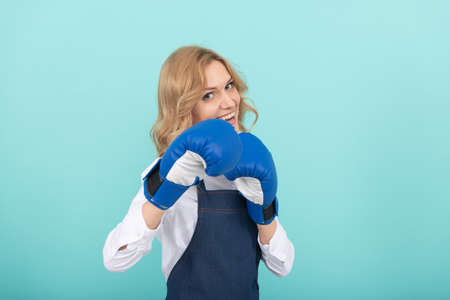 woman in apron and boxing gloves. housewife success. housework and household.の写真素材