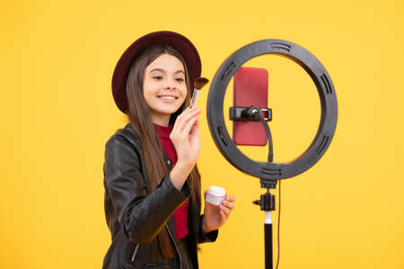 happy teen girl blogger use selfie led lamp and smartphone, makeup tutorial.の写真素材