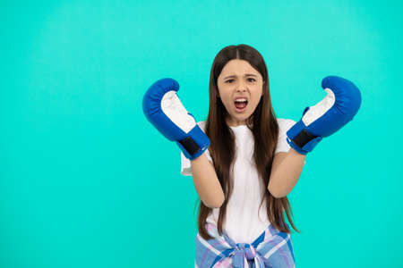 oh no. teen girl in boxing gloves. sport challenge. punching gloves. unhappy failed kid boxerの写真素材