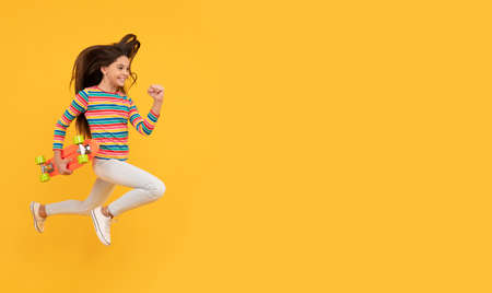 penny skateboard. skateboarding. cheerful child jump with penny board. teen girlの写真素材
