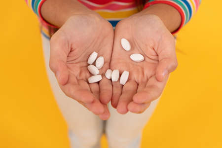 hands of teen girl presenting natural food additives or vitamin pills, medicationの写真素材