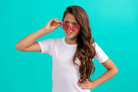 unhappy kid long curly hair in sunglasses casual style on blue background, fashion styleの写真素材