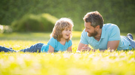 parenting and fatherhood. fathers day. happy cheerful father and son having fun in parkの写真素材