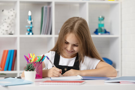 happy child writing in copybook at school lesson in classroom wear uniform, back to schoolの写真素材