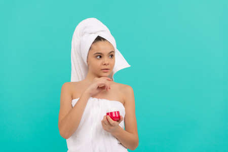 thinking girl hold hair mask. child with skin cream. daily habit and personal care.の写真素材