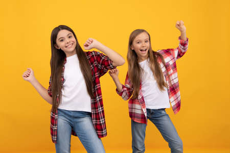 happy kids in casual checkered shirt having fun on yellow background, friendshipの写真素材