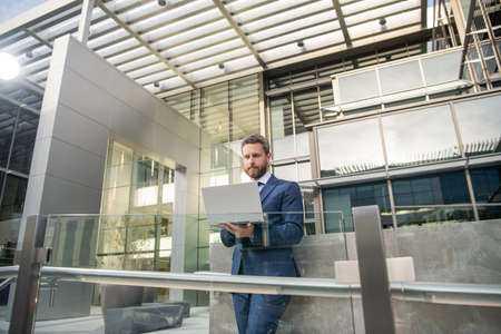 mature business man in formalwear work online on computer outdoor, freelance