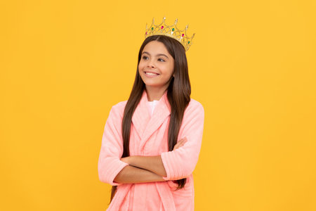 selfish happy teen girl in home terry bathrobe and princess crown, childhood happinessの写真素材