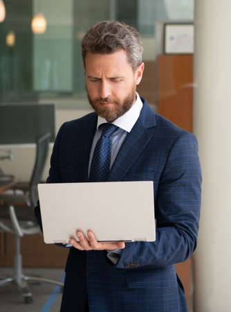 mature concentrated businessman work online on modern computer outside the office, agile business.の写真素材