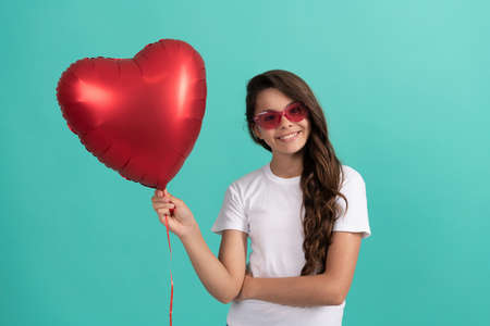 teen girl with party balloon. love present. smiling kid with love romantic gift.の写真素材