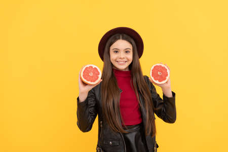 natural organic raw fresh food. healthy childhood. happy girl in leather hold grapefruit.の写真素材