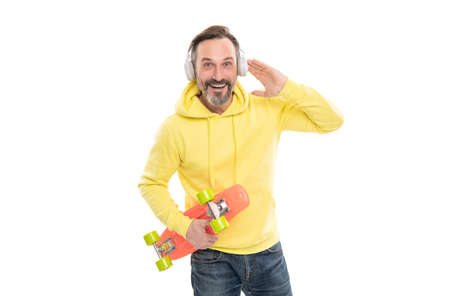 smiling senior guy listen music isolated on white. man in yellow hoody with skateboard.の写真素材