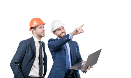 architects planning work. chief engineer and executive in hardhat use computer. ernet security. businessmen in helmet with laptop.の写真素材