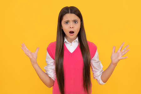 shocked teen school girl smiling with long hair on yellow background, shockの写真素材