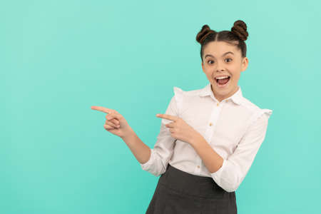 Happy primary school kid point fingers hand gesture for product advertising copy space, pointingの写真素材