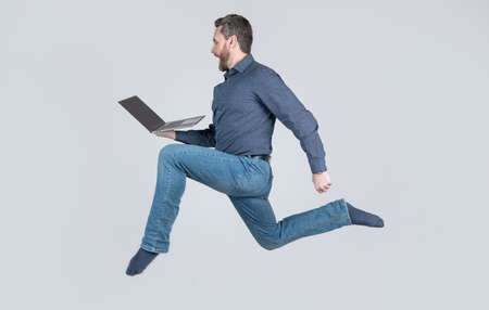 surprised energetic man running while working online on laptop hurry up for shopping, shopping.の写真素材