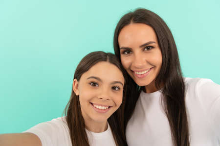 teen girl child with mom making selfie. family values and togetherness. positive smileの写真素材