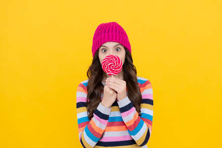 sweet tooth. yummy. surprised teen girl hold lollipop. lollipop lady. kid with colorful lollypop
