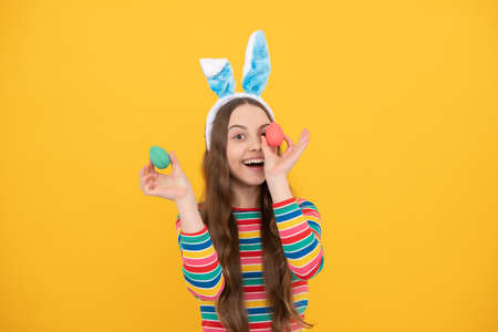 happy easter kid girl in rabbit bunny ears hold colorful eggs for holiday, egg huntの写真素材