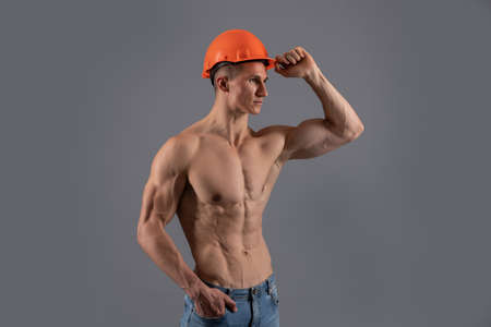 Shirtless construction man with fit torso wear hard hat grey background, constructorの写真素材
