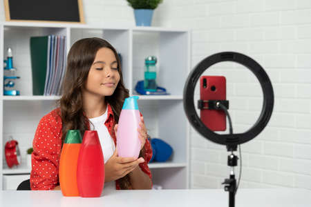 hair conditioner. smiling girl use selfie led. kid beauty blogger.の写真素材