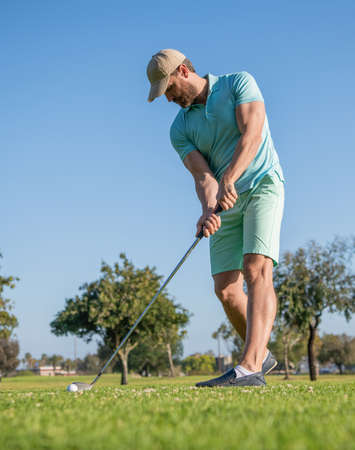 concentrated golfer in cap with golf club, golfingの写真素材
