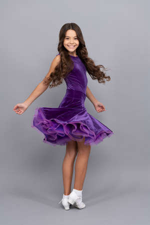 expressive child with long curly hair dancing in ballroom dress full length, dancerの写真素材