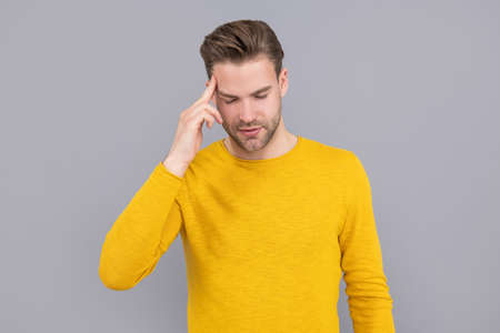Unhappy sick man suffer from migraine attack grey background, headacheの写真素材